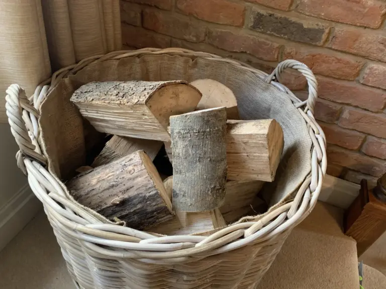 Rattan / Wicker log basket shown full with firewood