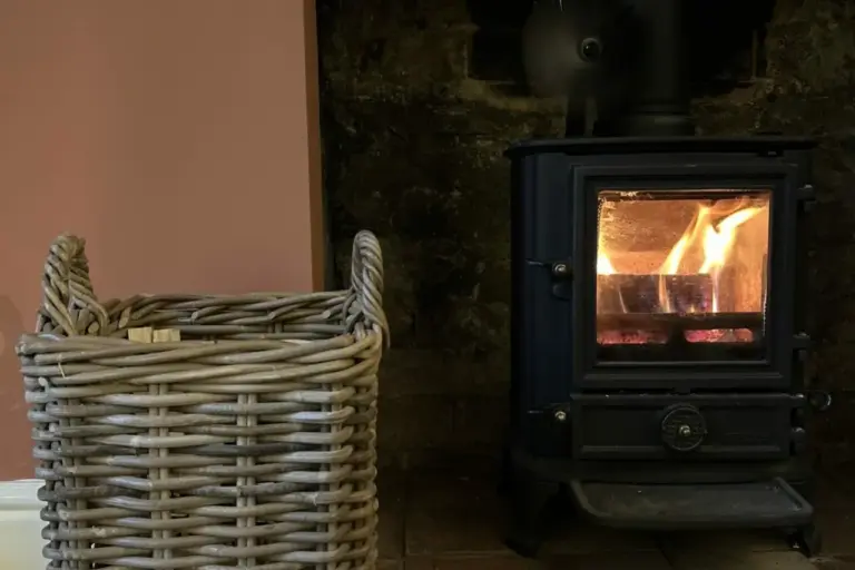 Rattan log basket next to a fireplace